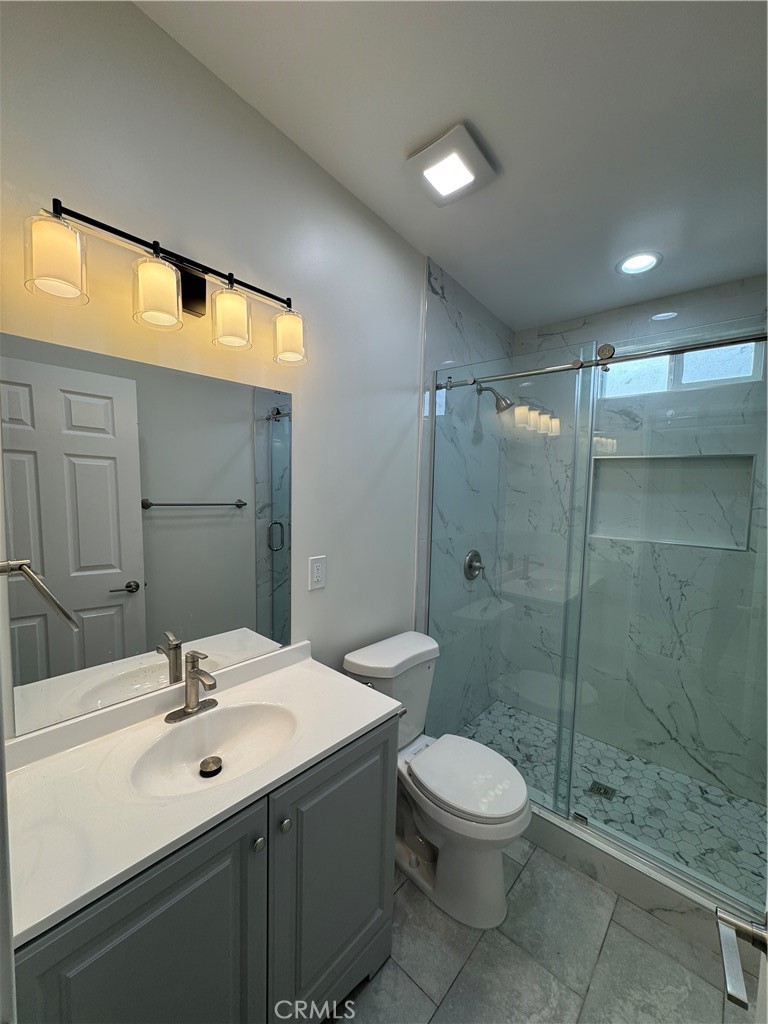 8418 Stewart And Gray Road Downey, CA 90241 - Photo 10 of 17 a bathroom with a sink toilet a mirror and shower
