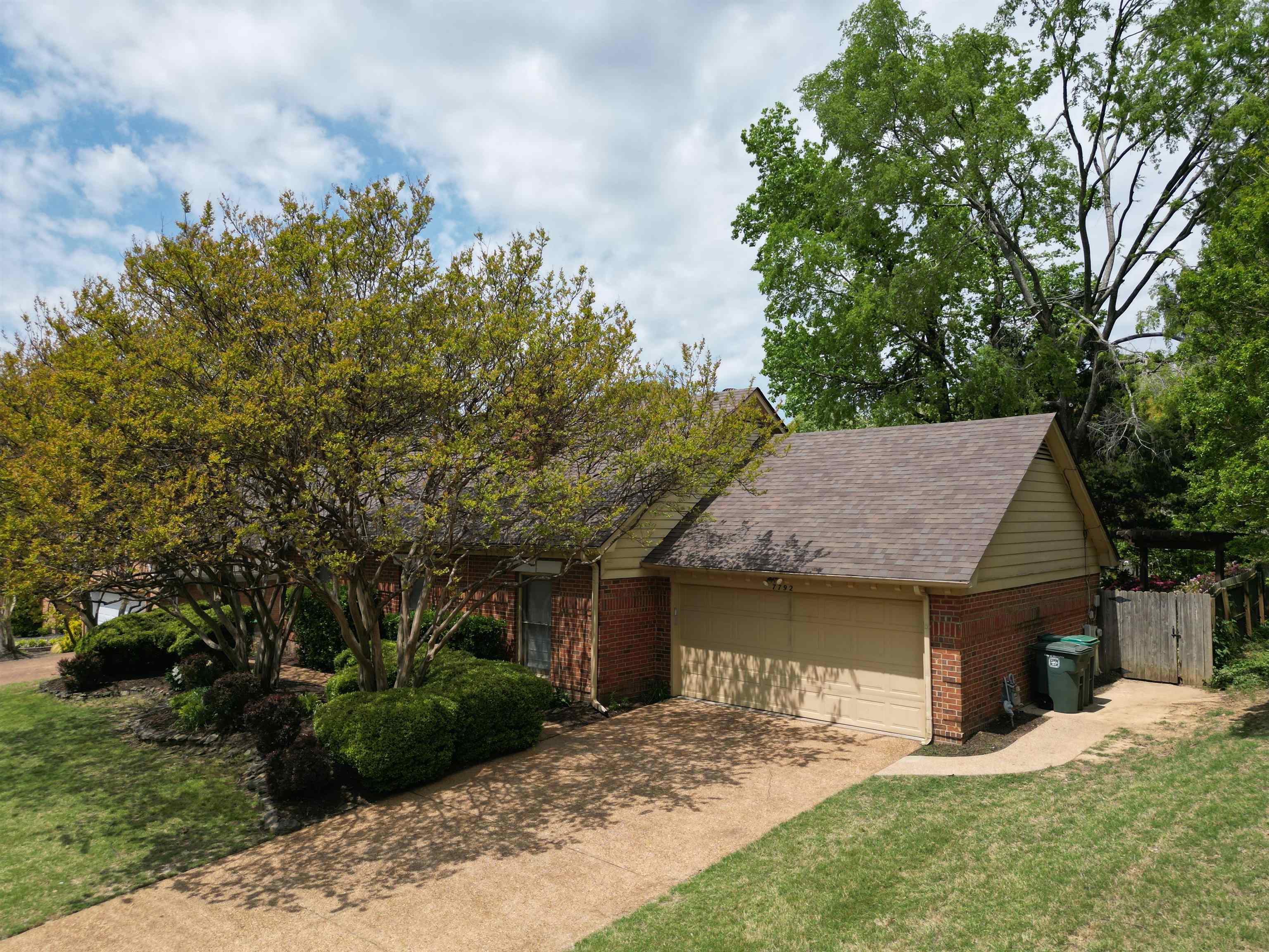 7792 Fawn Ridge Cove Memphis, TN 38016 - Photo 1 of 26 View of front of home with driveway, fence, brick siding, a garage, and a front yard