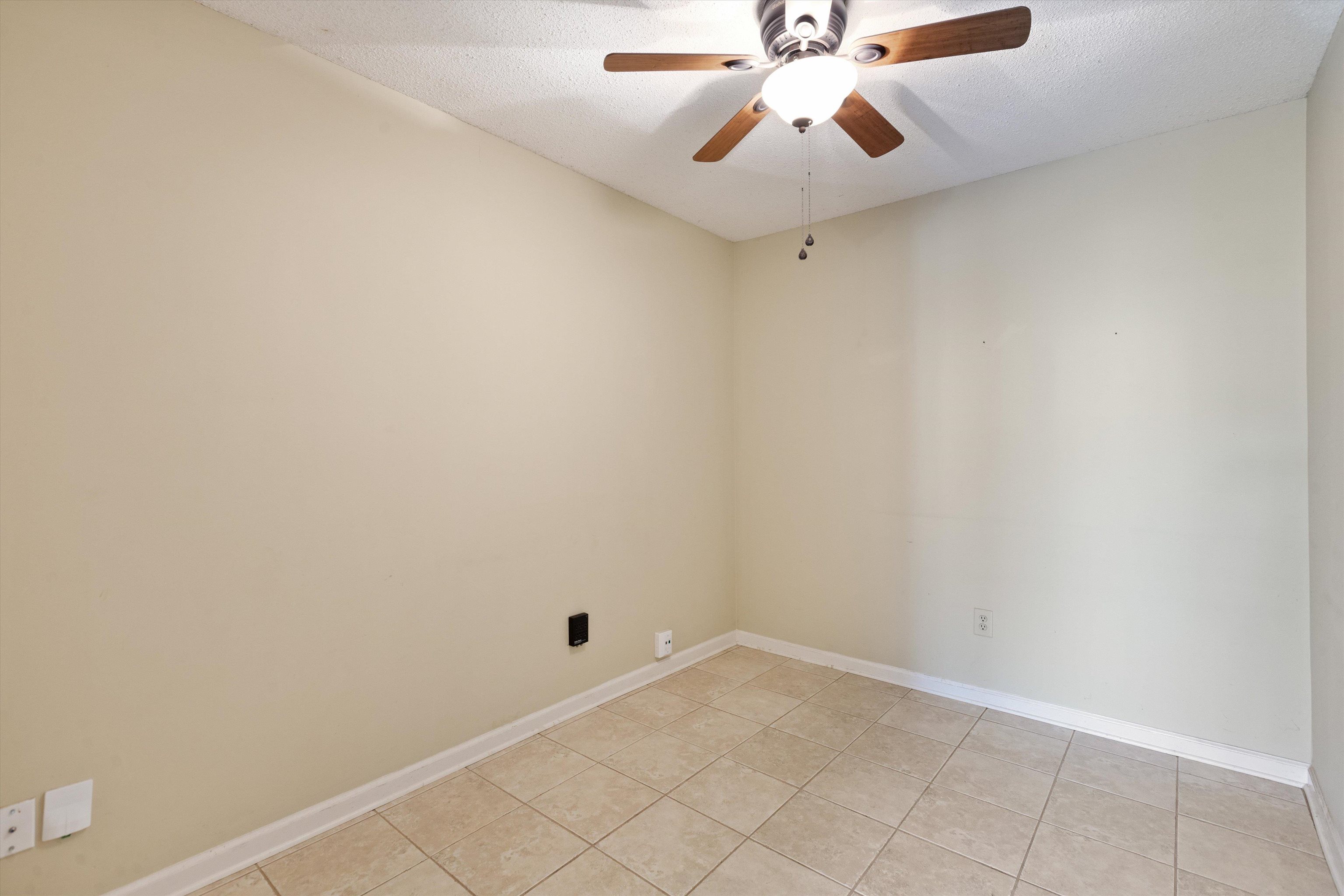 7792 Fawn Ridge Cove Memphis, TN 38016 - Photo 20 of 26 Empty room with a textured ceiling, ceiling fan, baseboards, and light tile patterned floors
