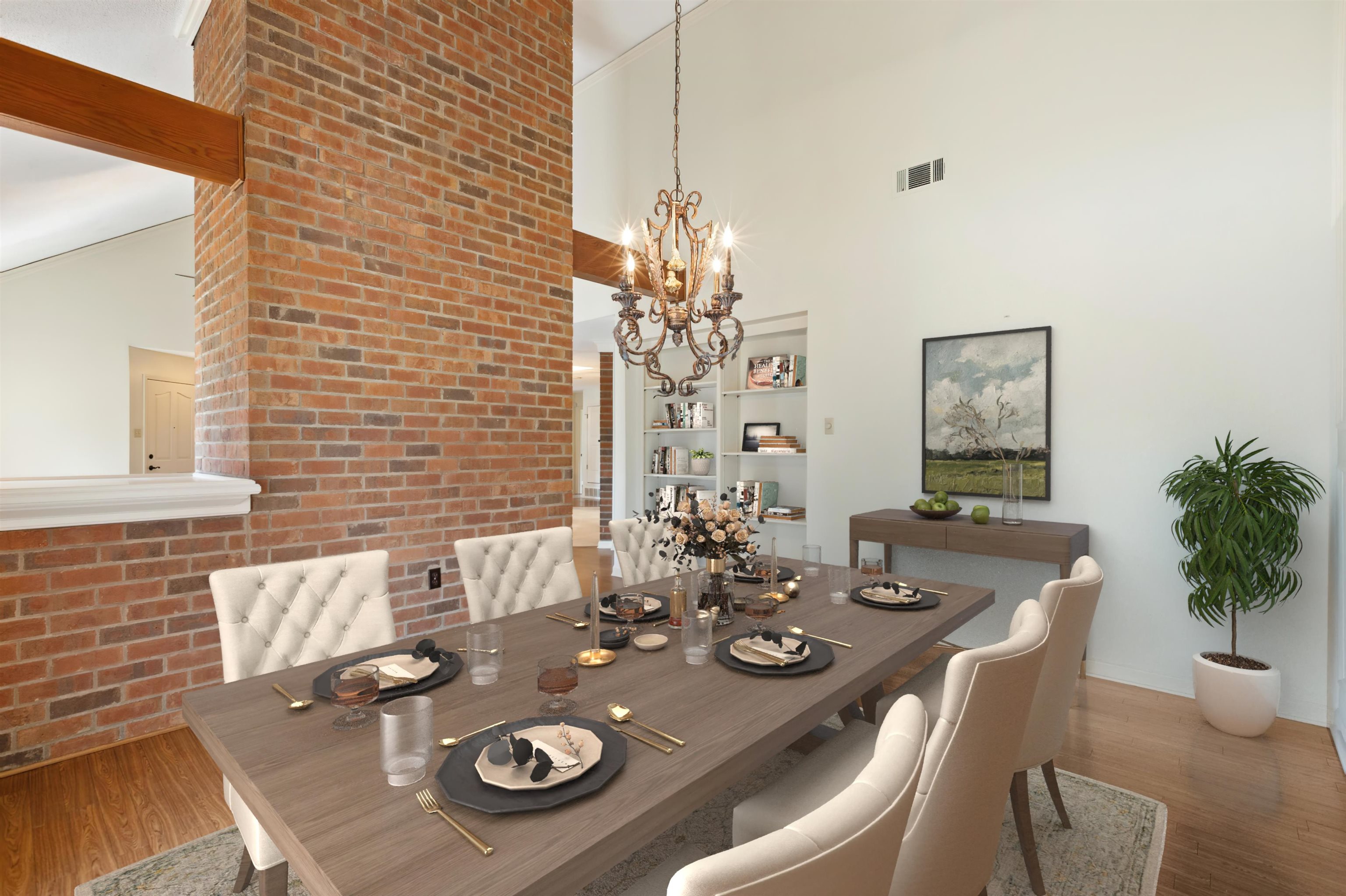 7792 Fawn Ridge Cove Memphis, TN 38016 - Photo 7 of 26 Dining area featuring visible vents, a high ceiling, a chandelier, and wood finished floors