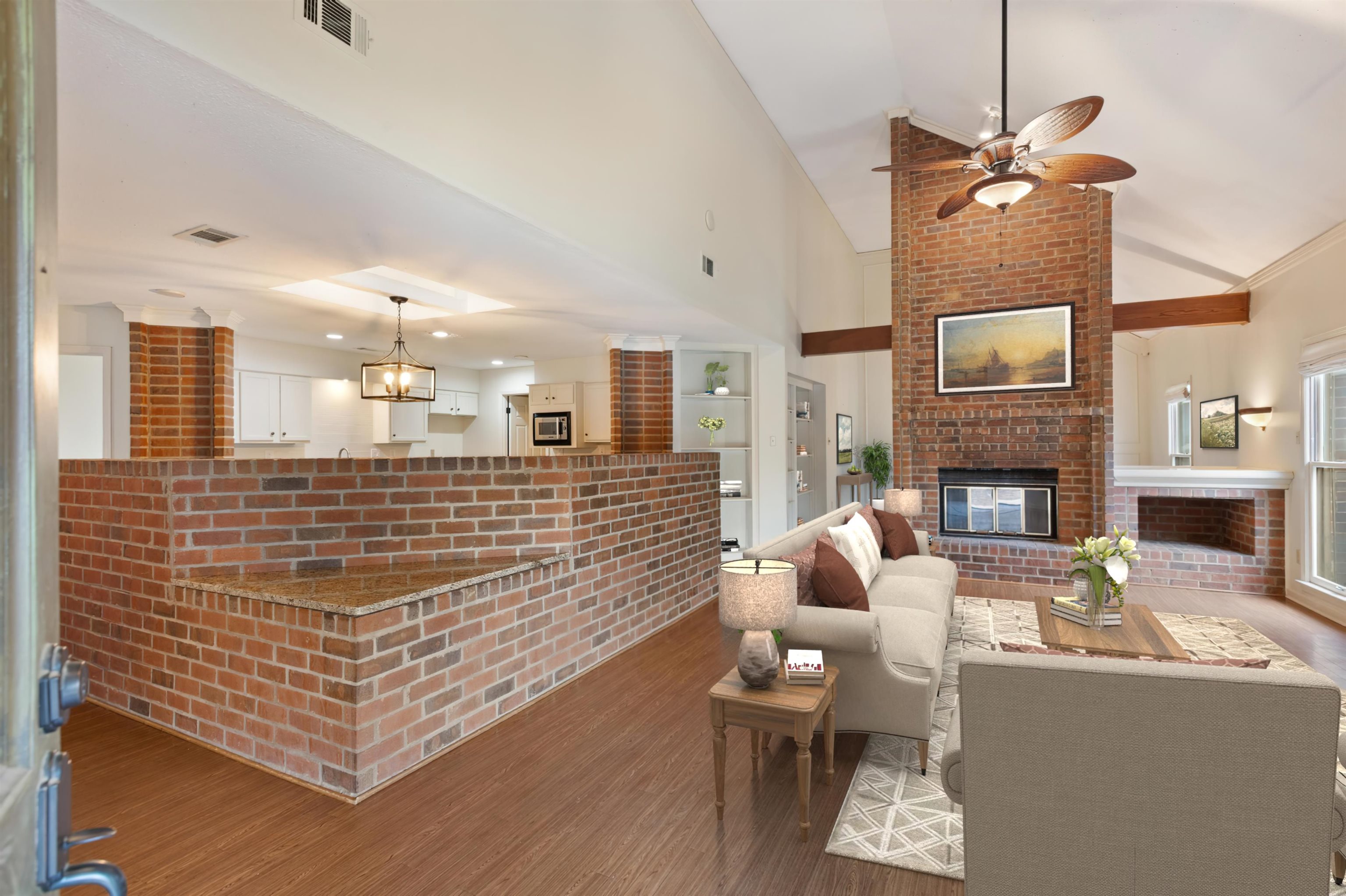 7792 Fawn Ridge Cove Memphis, TN 38016 - Photo 8 of 26 Living room with visible vents, a brick fireplace, a ceiling fan, and wood finished floors