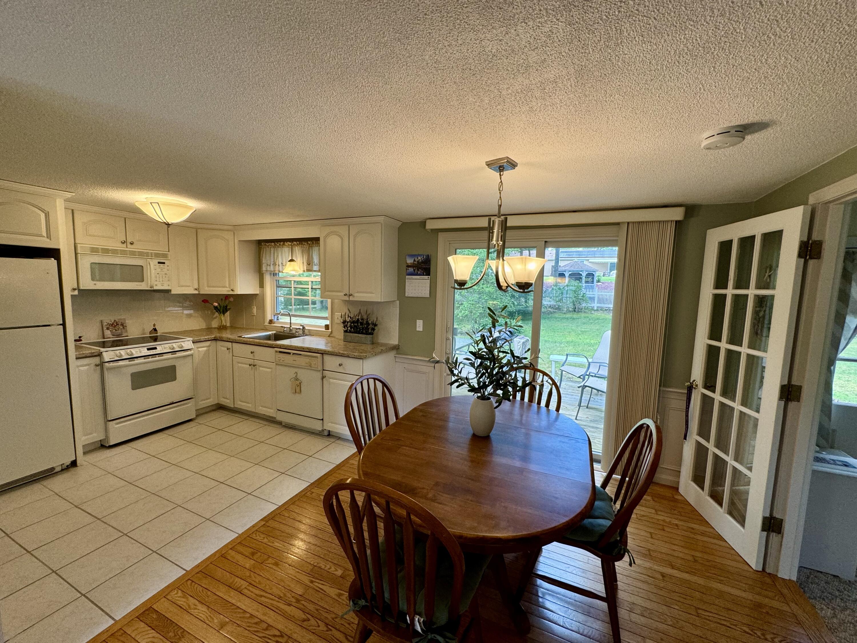 173 Nottingham Drive Centerville, MA 02632 - Photo 11 of 54 a view of a dining room and livingroom with furniture wooden floor a rug a potted plant and a chandelier