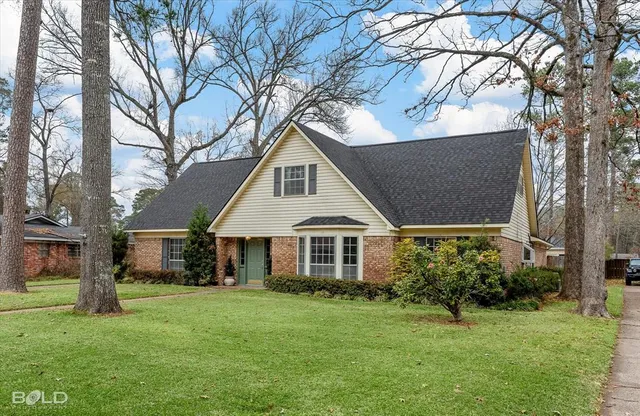 a front view of a house with a garden and yard