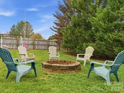 a view of a chairs and table in the back yard of the house