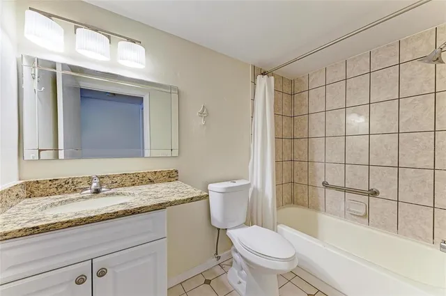 a bathroom with a granite countertop sink a toilet and shower
