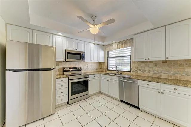 a kitchen with granite countertop cabinets stainless steel appliances and a counter space