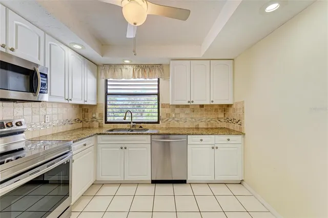a kitchen with a stove sink and cabinets