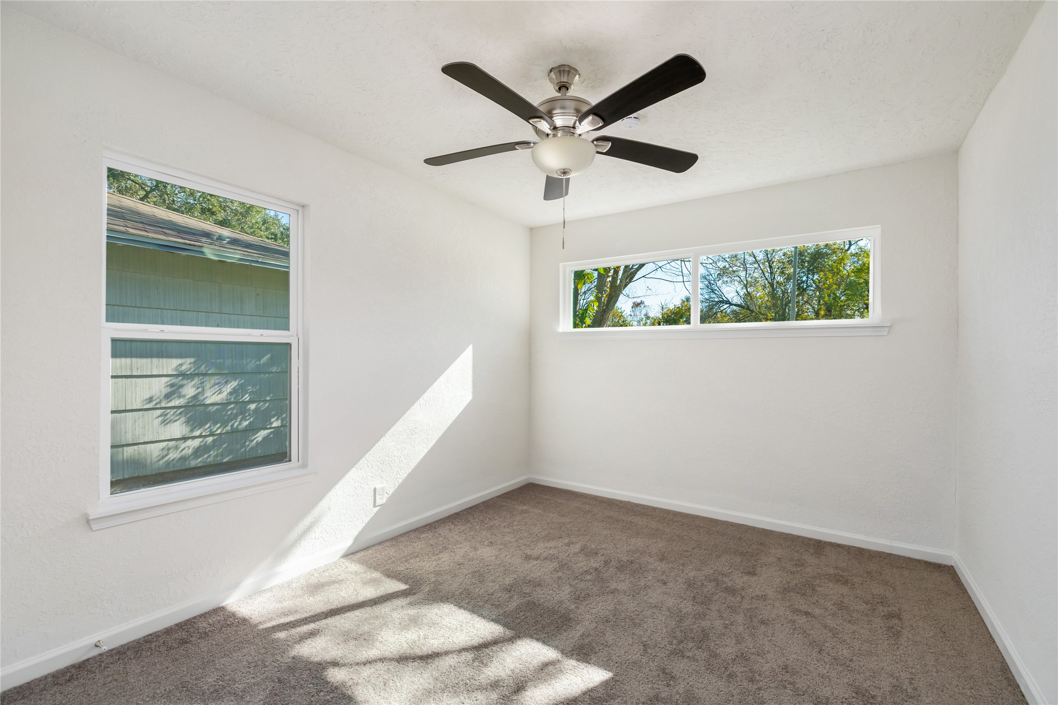 5915 Beldart Street Houston, TX 77033 - Photo 12 of 15 an empty room with windows and ceiling fan