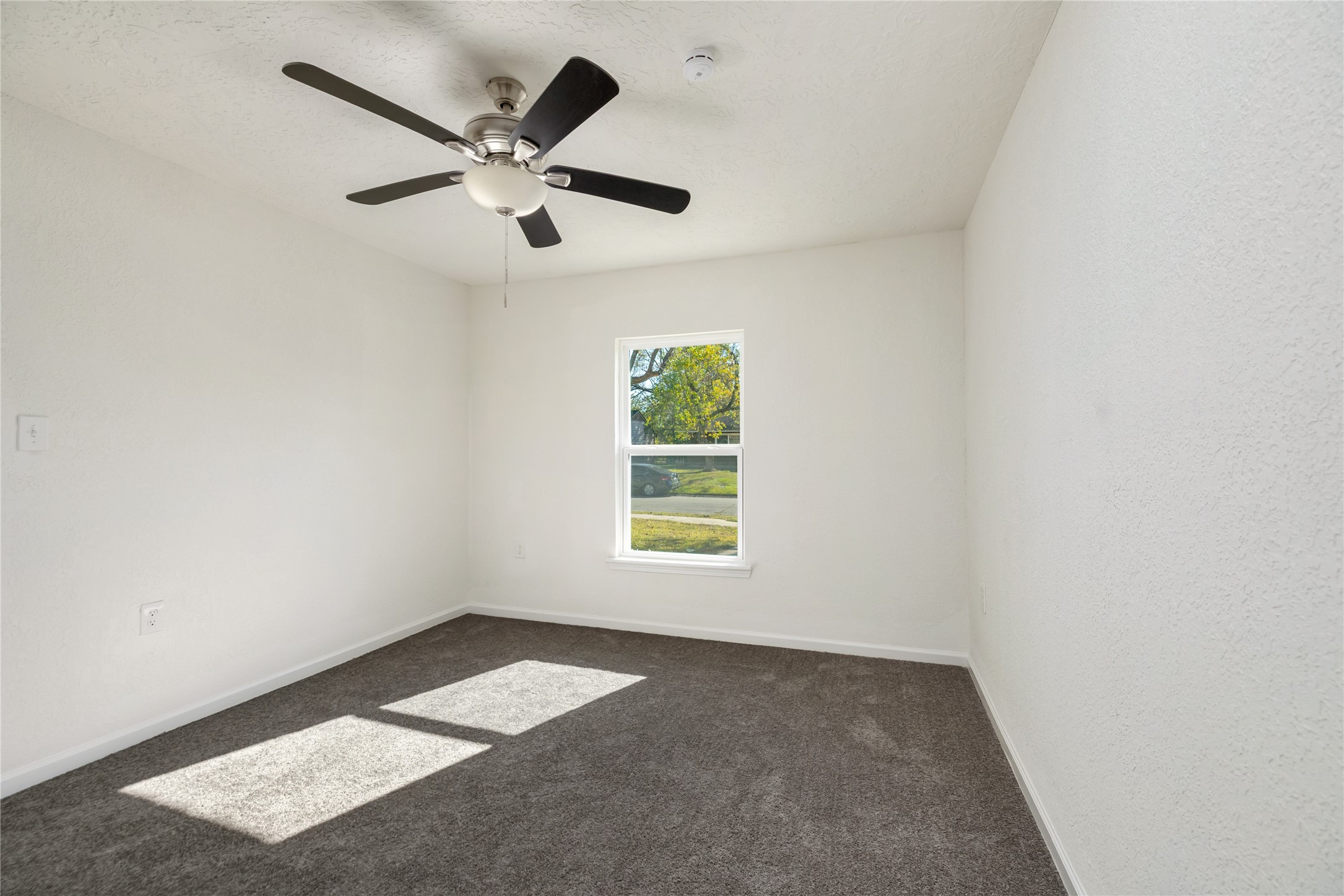 5915 Beldart Street Houston, TX 77033 - Photo 6 of 15 an empty room with windows and ceiling fan