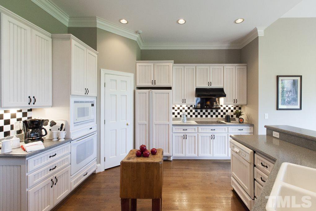 5 Pearse Wynd Road Bahama, NC 27503 - Photo 9 of 25 a kitchen with granite countertop white cabinets white stainless steel appliances and sink