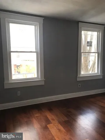 an empty room with wooden floor and a window