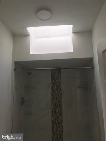 a bathroom with a granite countertop bathtub shower sink vanity and toilet