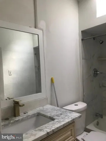 a white toilet sitting next to a bath tub