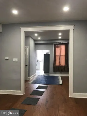 a view of a hallway with wooden floor and cabinet