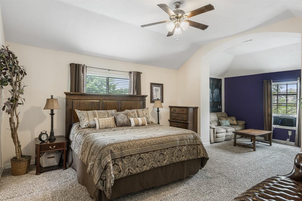 2877 Fenwick Street Grand Prairie, TX 75052 - Photo 17 of 27 a bedroom with a bed and a chandelier