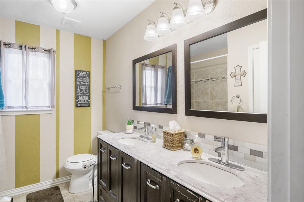 2877 Fenwick Street Grand Prairie, TX 75052 - Photo 23 of 27 a bathroom with a granite countertop toilet sink and a mirror
