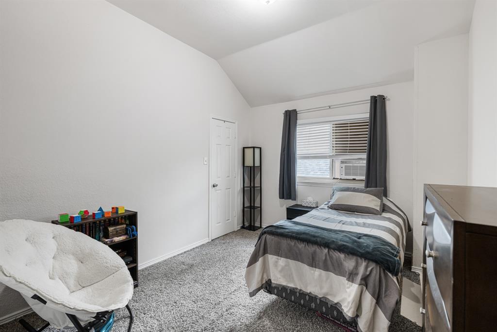 2877 Fenwick Street Grand Prairie, TX 75052 - Photo 24 of 27 a bedroom with a bed and a table in it