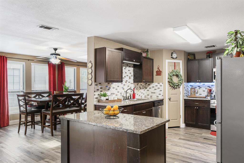 2877 Fenwick Street Grand Prairie, TX 75052 - Photo 8 of 27 a kitchen with refrigerator and chairs