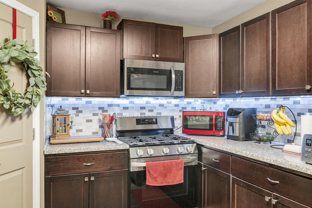 2877 Fenwick Street Grand Prairie, TX 75052 - Photo 9 of 27 a kitchen with granite countertop stainless steel appliances a stove microwave and sink