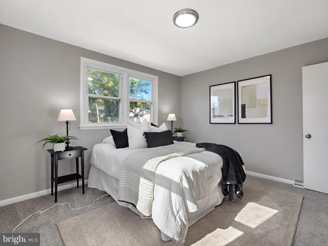 a bedroom with two beds lamp and a window