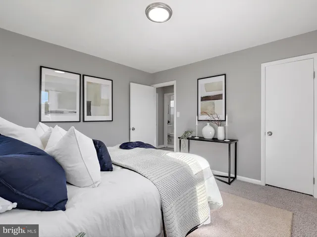 a bedroom with a bed and a painting on the wall