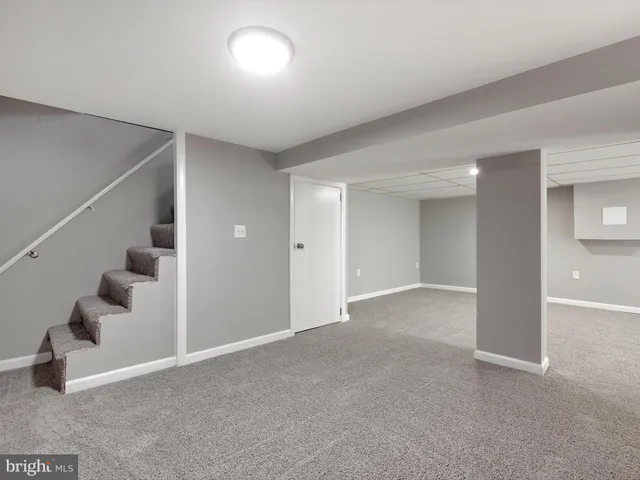 a view of an empty room with stairs and white walls