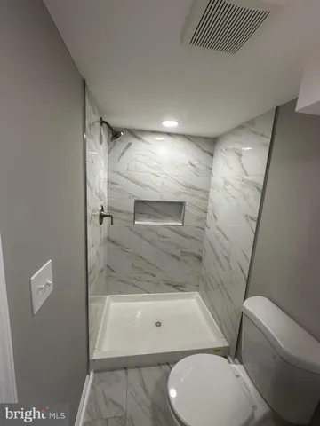 a bathroom with a toilet and a shower