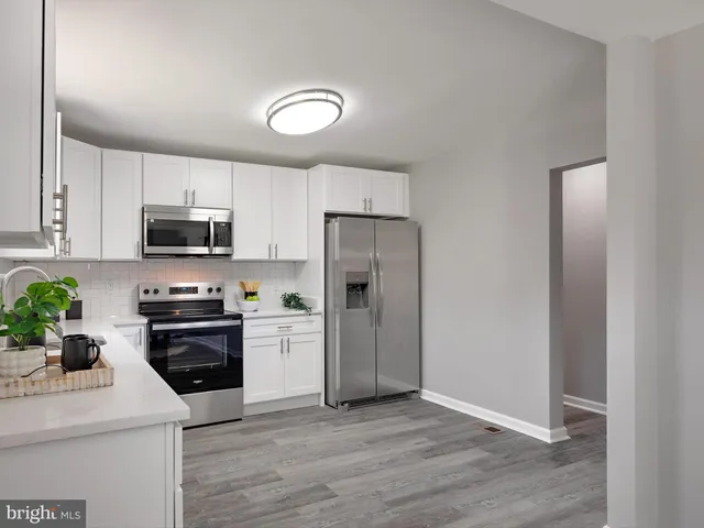 a kitchen with a sink a microwave a refrigerator and cabinets