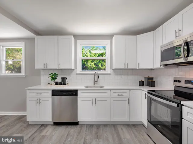 a kitchen with white cabinets white stainless steel appliances and sink
