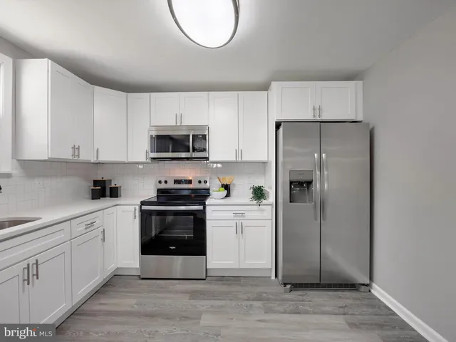 a kitchen with a refrigerator sink and cabinets