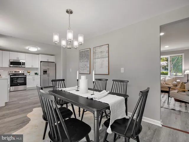 a view of a dining room with furniture a chandelier and wooden floor