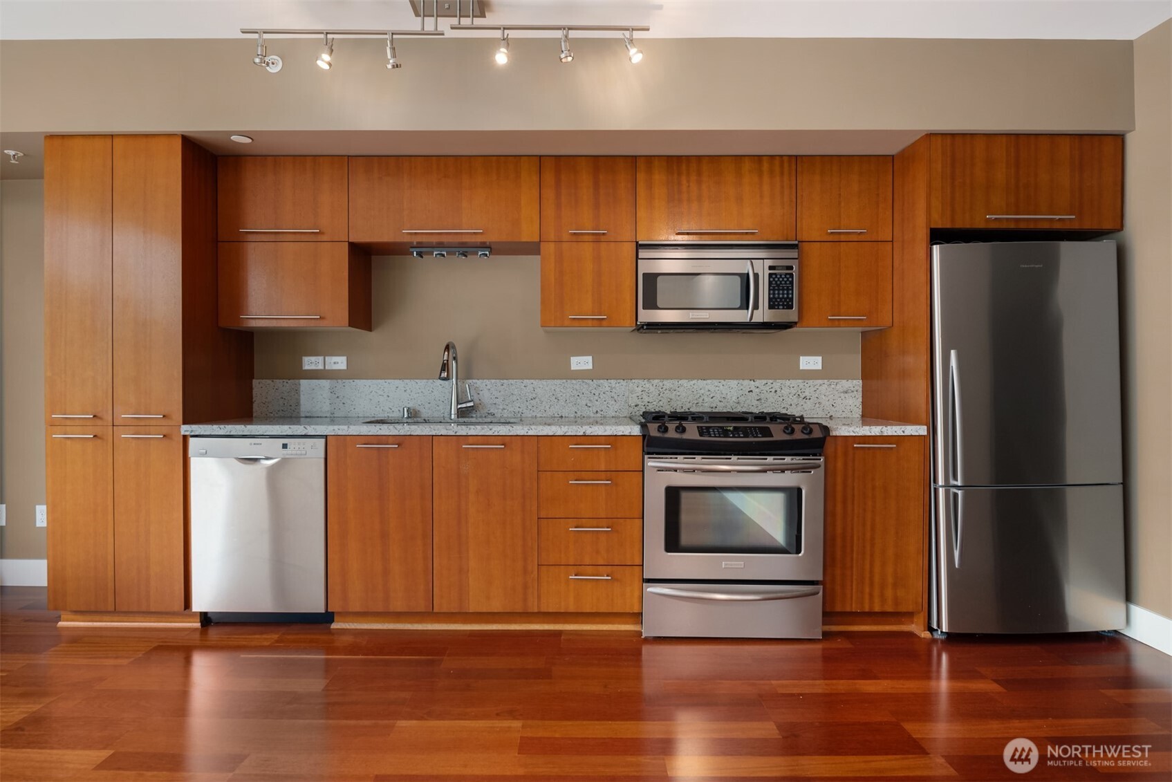 2911 2nd Avenue, Unit 310 Seattle, WA 98121 - Photo 9 of 40 a kitchen with granite countertop wooden cabinets and stainless steel appliances