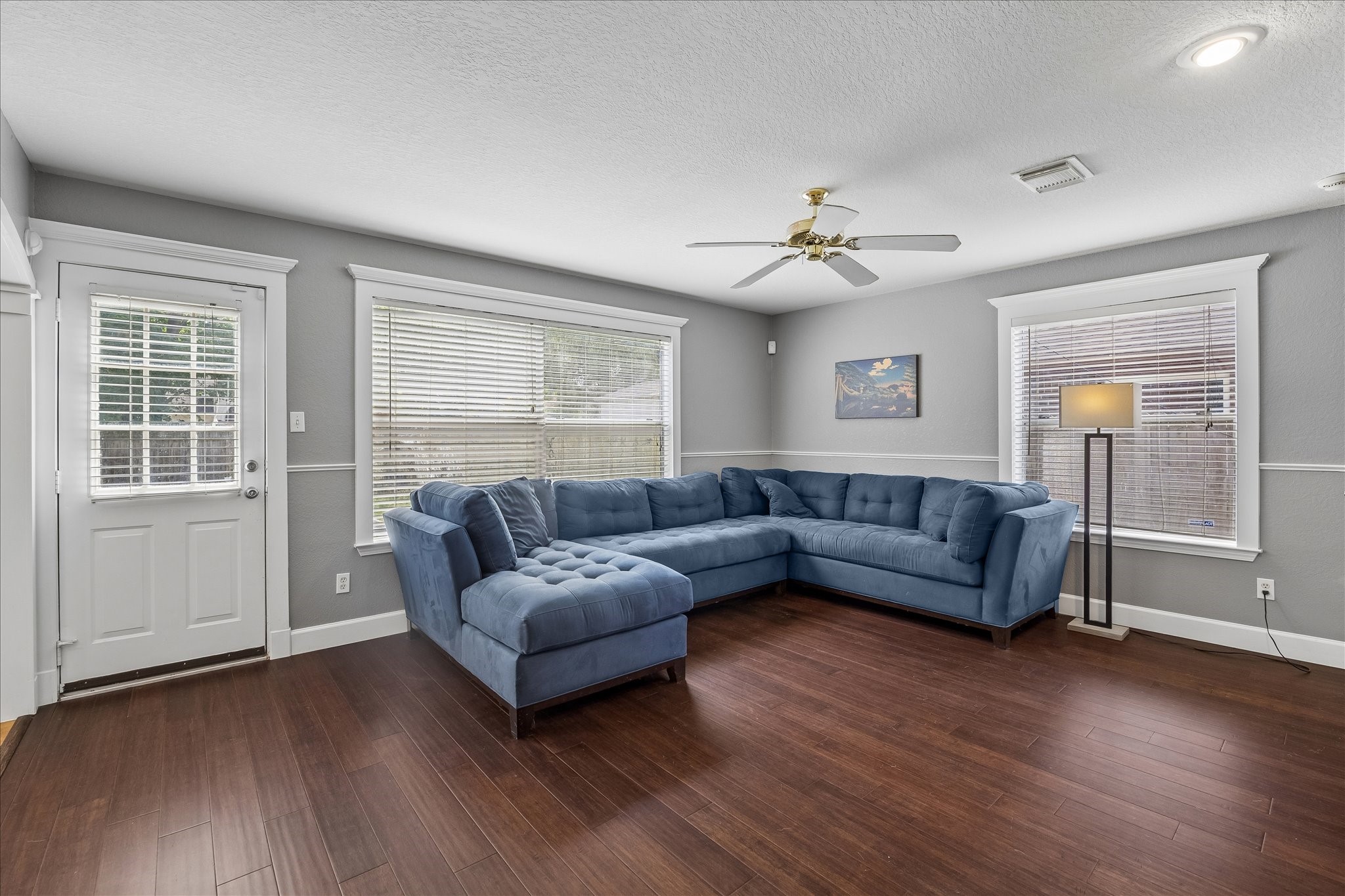 23234 Grand Rapids Lane Spring, TX 77373 - Photo 15 of 30 Comfortable family living area with rich wood flooring and oversized windows brings in beautiful natural light throughout the day.