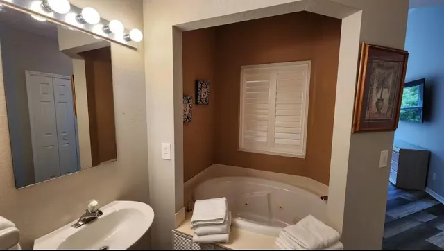 a bathroom with a tub shower and sink