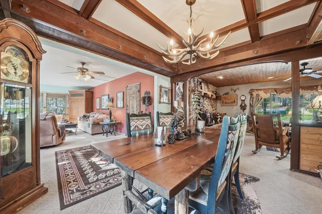 a kitchen with stainless steel appliances granite countertop a stove top oven a sink dishwasher a dining table and chairs with wooden floor