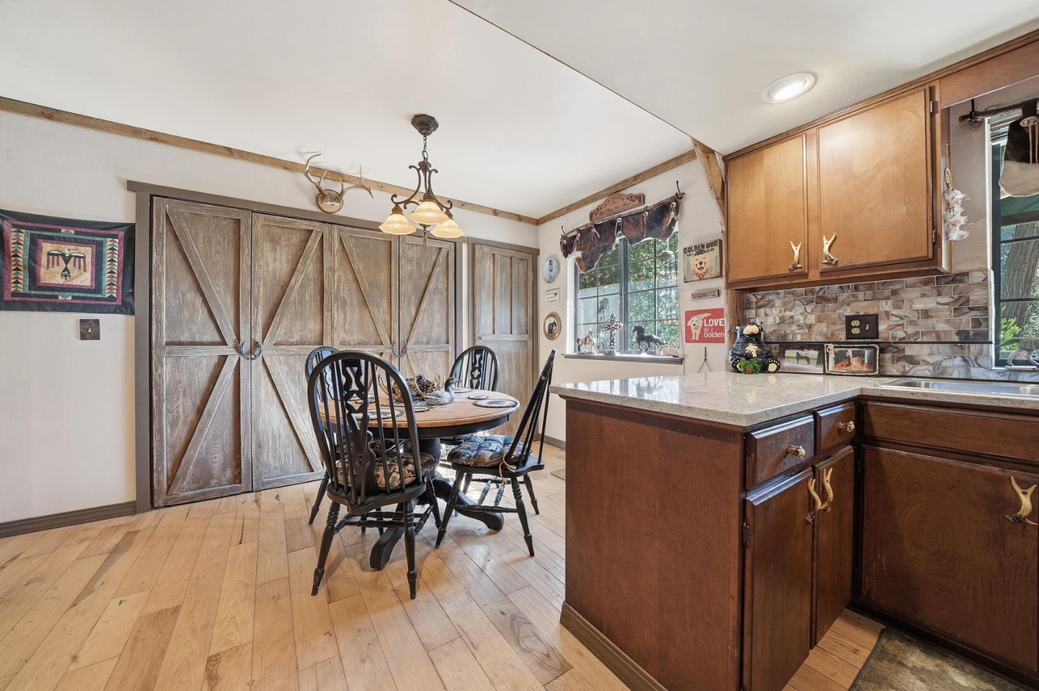 23140 Shake Ridge Road Volcano, CA 95689 - Photo 32 of 81 a kitchen with a table chairs sink and wooden floor