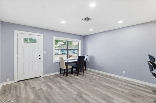 a view of a work space with wooden floor and a window