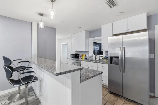 a kitchen with stainless steel appliances granite countertop a refrigerator and a stove top oven