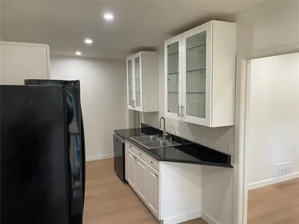 a kitchen with granite countertop cabinets and refrigerator