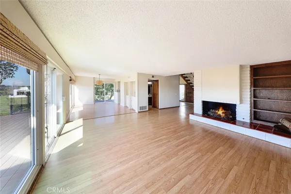 a view of a room with wooden floor and fireplace