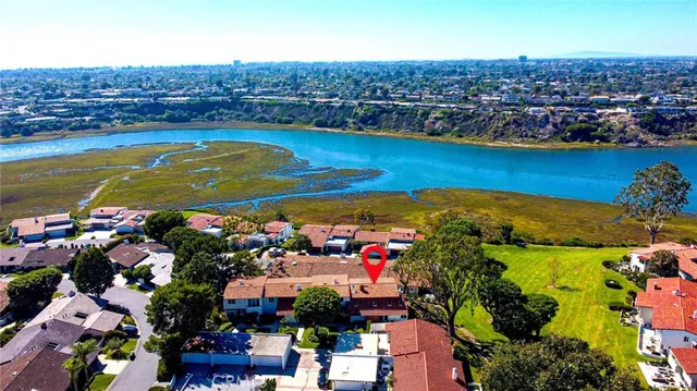 an aerial view of ocean and residential houses with outdoor space