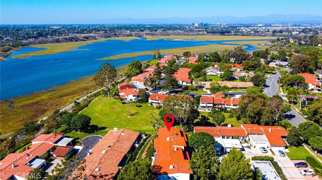 an aerial view of ocean and residential houses with outdoor space