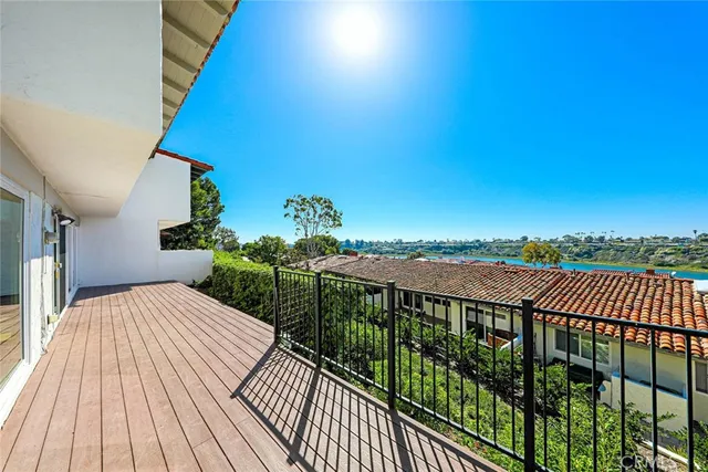 a view of a balcony with wooden floor and fence