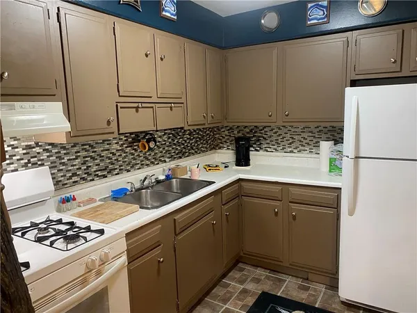 a kitchen with a sink a stove and refrigerator