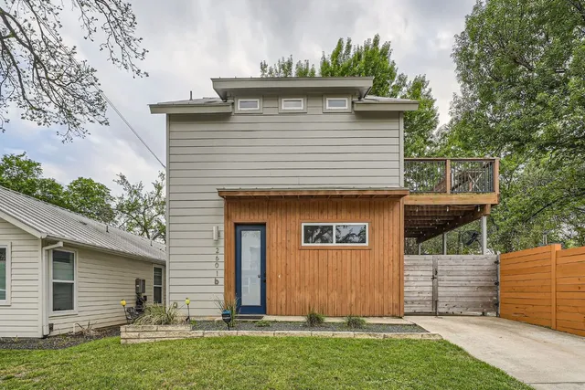 a view of a yard with wooden fence and a large tree