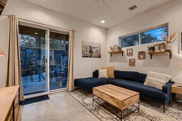 a living room with furniture and a glass door