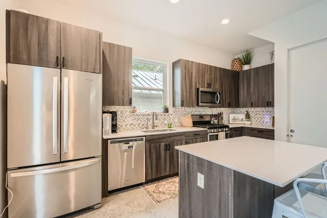 a kitchen with stainless steel appliances a stove a sink and a microwave