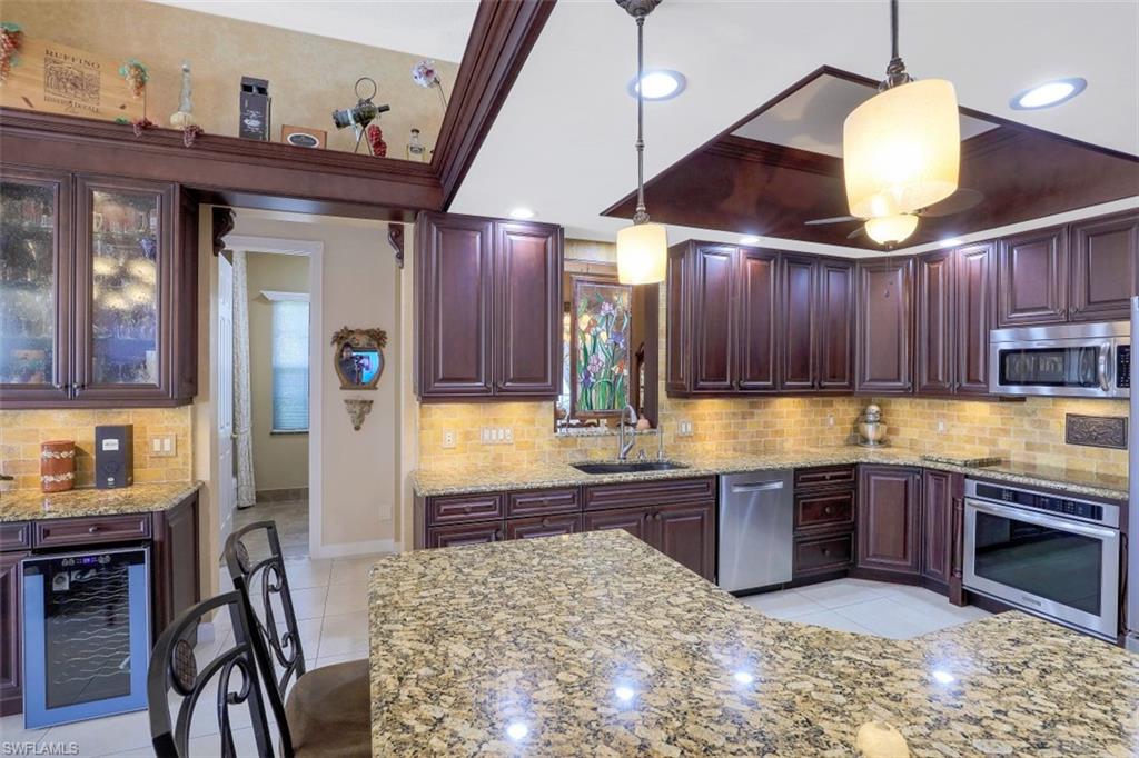 5156 Inagua Way Naples, FL 34119 - Photo 6 of 35 Totally re-imagined kitchen features cherry cabinets with drawers and pull-outs for easy access