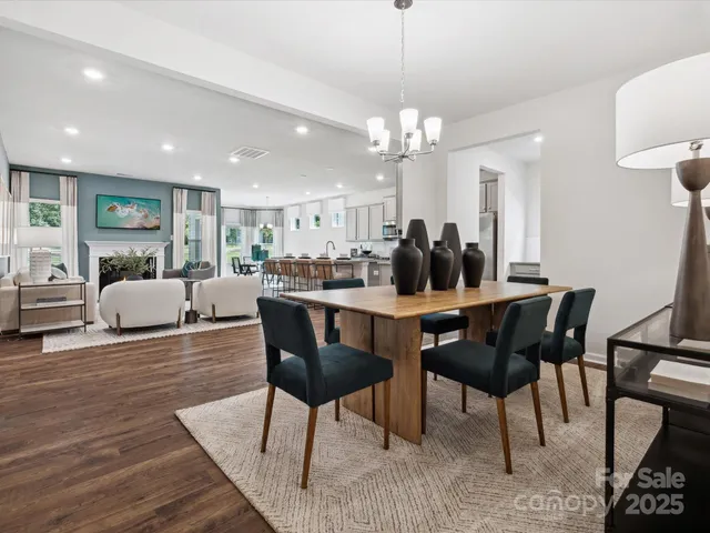 a view of a dining room with furniture a chandelier and wooden floor