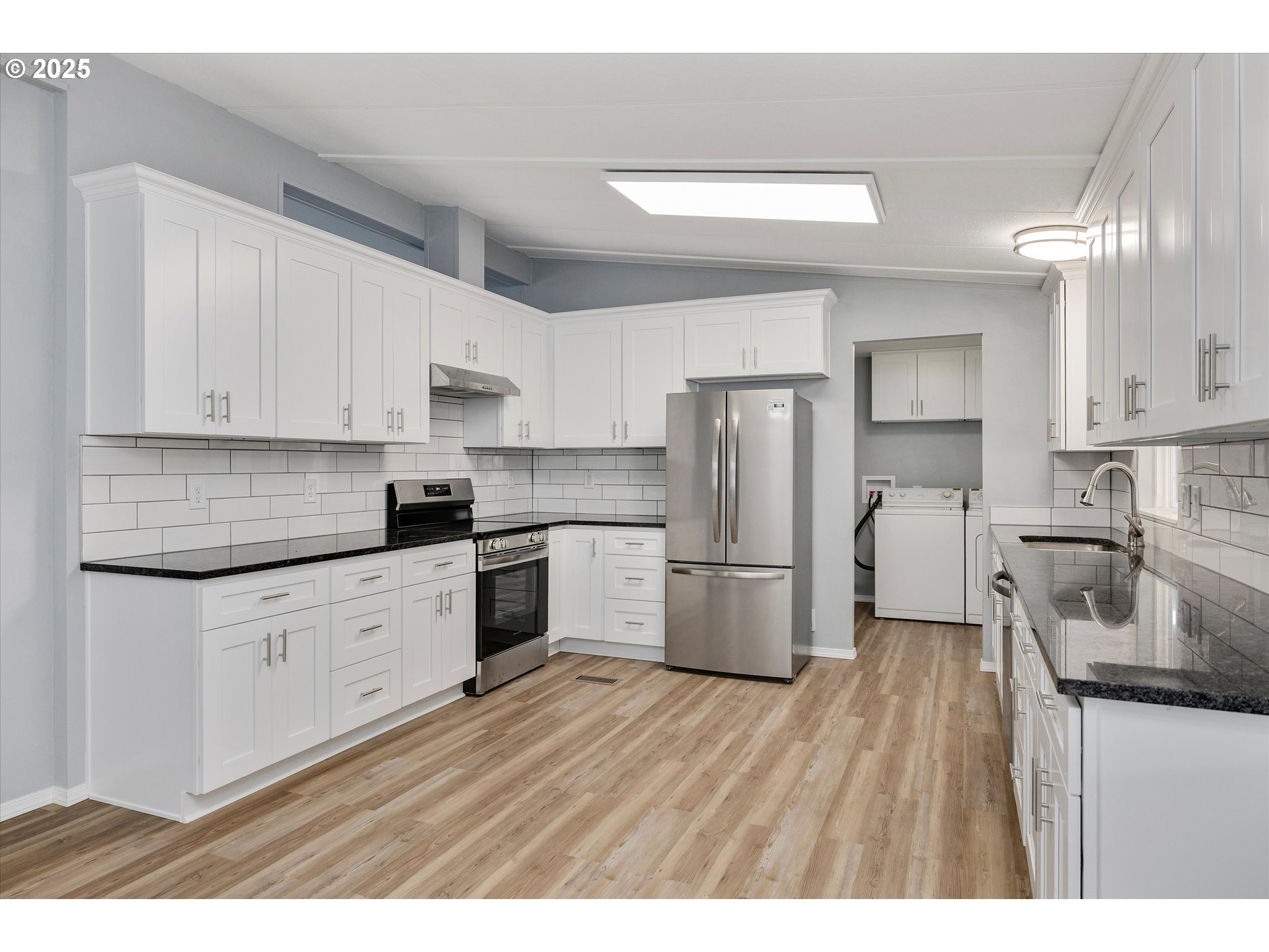 835 Southeast 1st Avenue, Unit 17 Canby, OR 97013 - Photo 11 of 33 a kitchen with a refrigerator a stove a sink and white cabinets with wooden floor